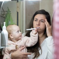 Schminktipps für müde Mamas Eine müde Mama und ihr Baby im Badezimmer.