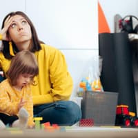 Genervte Mutter mit spielender Tochter. Genervte Mutter mit spielender Tochter.