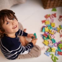 Kind spielt mit Buchstaben. Kind spielt mit Buchstaben.