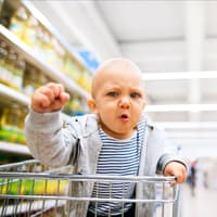 Das Kind im Einkaufswagen "fesseln" ... Kind protestiert im Einkaufswagen.