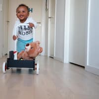 Kleiner Junge lernt laufen am Lauflernwagen Kleiner Junge lernt laufen am Lauflernwagen