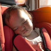 Müssen wir unsere Kinder im Auto wirklich mit Sonnencreme einschmieren? Ein Baby sitzt im Kindersitz des Autos, während die Sonne hereinscheint.