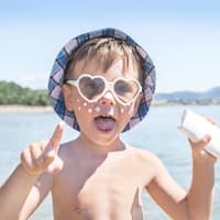 "Mein Kind hasst Eincremen!" Ein Kind mit Sonnencreme im Gesicht