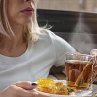 Eine Frau nimmt heißen Pfefferminztee zu sich. Eine Frau nimmt heißen Pfefferminztee zu sich.