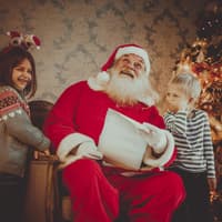 Nikolaus mit zwei Kindern lachen über einen lustigen Nikolausspruch. Nikolaus mit zwei Kindern lachen über einen lustigen Nikolausspruch.