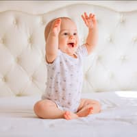 Geschlechtsneutrale Namen können an Jungen oder Mädchen vergeben werden. Ein Baby, das sich freut.