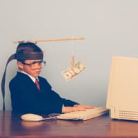 Alles nur für die Belohnung machen ... ? Ein Kind, das vor einem Computer sitzt und einen Geldschein vor sich flattern sieht.