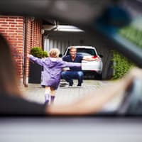 Kind läuft vom Auto der Mama zum Papa. Kind läuft vom Auto der Mama zum Papa.