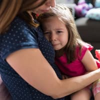 Mutter tröstet ihre kleine Tochter und hält sie im Arm. Mutter tröstet ihre kleine Tochter und hält sie im Arm.