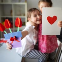 Selbstgebastelte Karten zum Muttertag Zwei Mädchen mit selbstgebastelten Karten