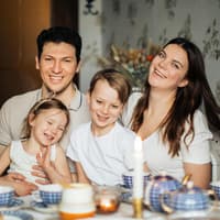 Rasenmäher-Eltern versuchen alle vermeintlichen Probleme ihrer Kinder abzufangen. Eine glückliche, vierköpfige Familie ist abgebildet.