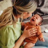 Mama versucht, ihr Neugeborenes zu beruhigen – manchmal gar nicht so einfach. Mama versucht, ihr Neugeborenes zu beruhigen.