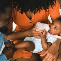 Auch beim Fläschchengeben ist Bonding möglich. Eltern stillen Baby auf dem Arm.