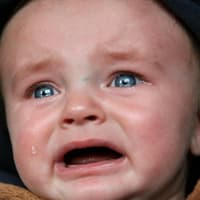 Babys haben immer einen Grund, wenn sie weinen. Weinendes Baby mit Kapuze.