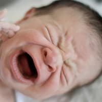 Achtung, eine Wärmflasche kann bei Babys zu üblen Verbrennungen führen. Baby schreit aus voller Kehle.