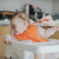 Das Baby gibt oft klare Zeichen, wenn es noch zu früh für Beikost ist. Ein Baby, das mit Brei gefüttert werden soll, dreht seinen Kopf weg.