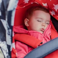 Frische Luft tut auch kranken Kindern gut – es gibt aber Ausnahmen. Kind liegt schlafend im Buggy.