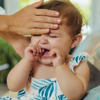 Wenn das Kind nicht mehr aufhört zu schreien und hohes Fieber hat: Ab zum Arzt! Mutter fühlt heiße Stirn eines schreienden Babys.