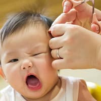 Babys sind nicht immer begeistert, wenn man ihnen die Haare schneiden möchte.