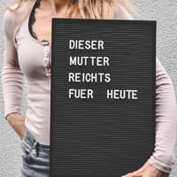 Mütter müssen lernen, die Care-Arbeit nicht ganz alleine zu stemmen. Frau mit Schild "Dieser Mutter reicht's für heute".