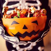 Halloween feiern mit den Kleinen: Ja oder Nein? Welches Lager seid ihr? Kind hält Halloween-Schale.