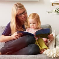 Bücher können Kindern dabei helfen, die Trennung der Eltern zu verarbeiten. Mutter liest mit Kind ein Buch.
