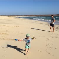 Auf den Kapverden findet man Kilometer lange Sandstrände – ideal für Kinder. Vater und Kind am Strand auf den Kapverden.