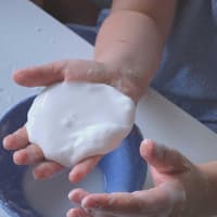 Mit Oobleck lassen sich tolle Experimente durchführen – eure Kinder werden begeistert sein. Kind hält Oobleck in der Hand.