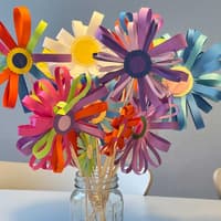 Die versprühen gute Laune: selbst gebastelte Papierblumen auf dem Küchentisch. Ein Strauß selbst gebastelter Papierblumen