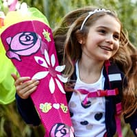 Die schönsten Glückwünsche zur Einschulung. Glückliches Mädchen mit Schultüte.