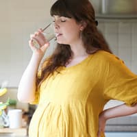 Mindestens 1,5 Liter sollten Schwangere täglich trinken, besser noch mehr. Schwangere trinkt ein Glas Wasser.