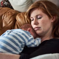 Kleine Gesten können Neu-Mamas super entlasten. Mama schläft mit Baby auf ihrem Bauch.