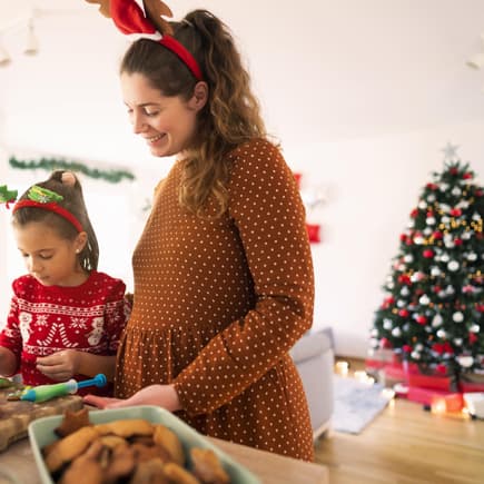 In der Schwangerschaft muss man auf bestimmte Dinge achten. Mutter und Kind backen Weihnachtskekse.