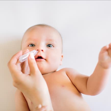 Baby bekommt Nasentropfen in die Nase geträufelt