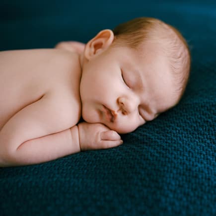Wenn sich das Baby nachts auf den Bauch dreht, sorgen sich viele Eltern. Ein Baby schläft in Bauchlage.