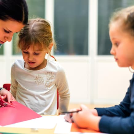 Erzieherin bastelt mit Kindern. Erzieherin bastelt mit Kindern.