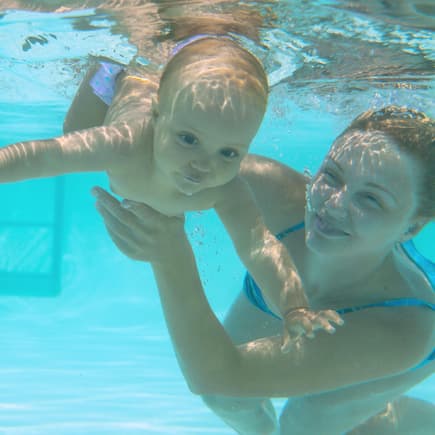Baby beim Tauchen im Babyschwimmkurs Baby beim Tauchen im Babyschwimmkurs