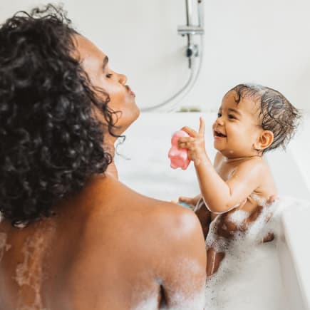 Eine Mutter badet mit ihrem Baby zusammen in der Badewanne. Eine Mutter badet mit ihrem Baby zusammen in der Badewanne.