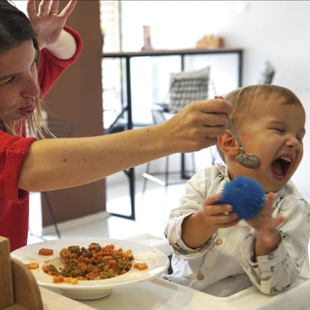 Ist es okay im Restaurant eigenes Essen für Kindern zu servieren? Eine Mutter versucht vergeblich ihr Kleinkind zu füttern.