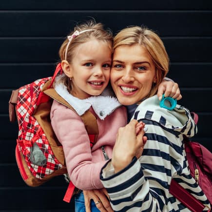 Tochter umarmt Mutter vor schwarzem Hintergrund. Tochter umarmt Mutter vor schwarzem Hintergrund.