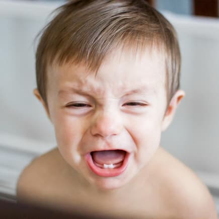 Kleiner Baby-Junge weint aufgrund von Zahnungsbeschwerden wie Durchfall Kleiner Baby-Junge weint aufgrund von Zahnungsbeschwerden wie Durchfall