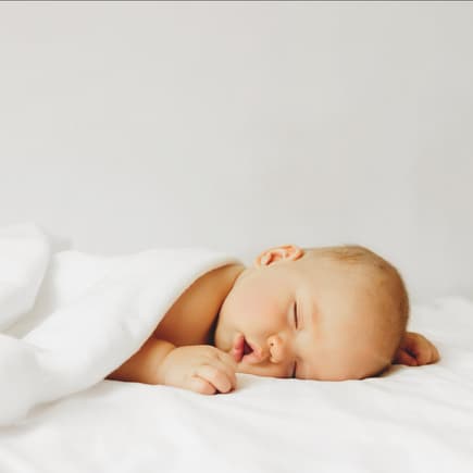 Baby schläft zugedeckt auf dem Bett. Baby schläft zugedeckt auf dem Bett.