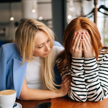 Warum die Familienplanung kein Smalltalk-Thema ist Eine Frau tröstet ihre Freundin