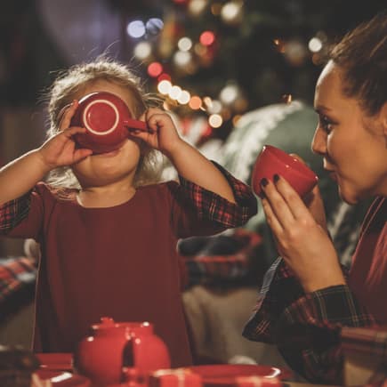 Kleines Mädchen trinkt mit ihrer Mama alkoholfreien Kinderpunsch zur Weihnachtszeit. Kleines Mädchen trinkt mit ihrer Mama alkoholfreien Kinderpunsch zur Weihnachtszeit.
