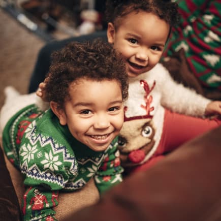 Zwei kleine Kinder in süßen Wiehnachtspullovern. Zwei kleine Kinder in süßen Wiehnachtspullovern.