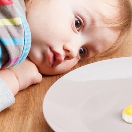 Baby schaut sich ein Spiegelei genau an. Baby schaut sich ein Spiegelei genau an.