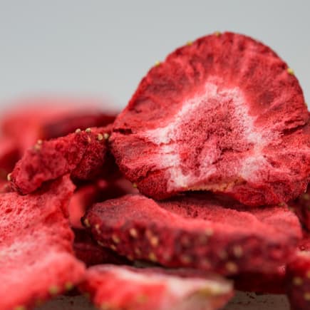 Gefriergetrocknete Früchte (wie etwa Erdbeeren) sind bei Kindern super beliebte Snacks. Nahaufnahme von gefriergetrockneten Erdbeeren