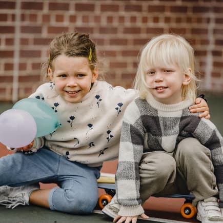 Dänische Kindermode ist vor allem lässig und cool Ein Mädchen und ein Junge auf einem Skateboard draußen