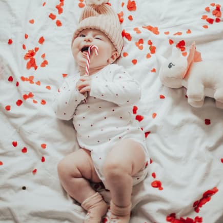 Baby liegt im Bett voller Herzen. Baby liegt im Bett voller Herzen.