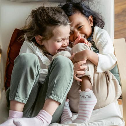 Sag-mal-Witze kommen bei Kindern super an. Zwei junge Mädchen lachen sich zusammen schlapp.